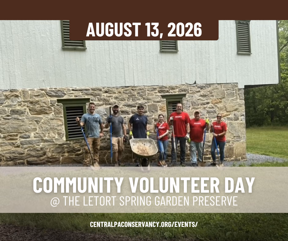 Group of volunteers with tools posing outside a stone building for Community Volunteer Day at The Letort Spring Garden Preserve, August 13, 2026.